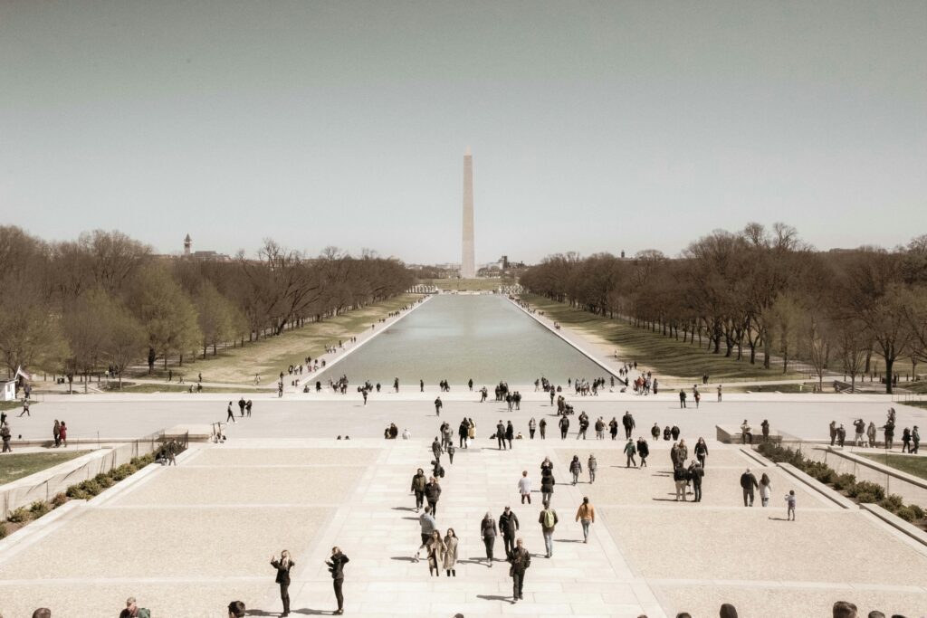 Vintage image of The Washington monument and reflecting pool with people walking around.